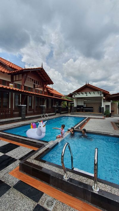 Kanak-kanak bermain di kolam dengan pelampung berbentuk unikorn