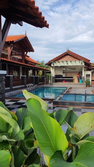 Halaman berjubin hitam putih membawa ke kolam dan wakaf terbuka.