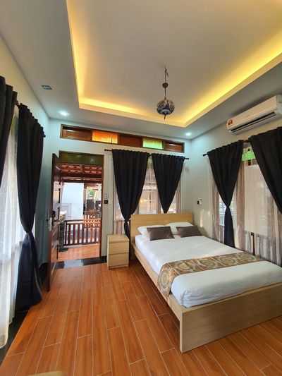 Bilik tidur dengan bantal kelabu dan pintu terbuka ke anjung